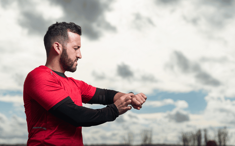 A runner on a track, alternating between sprints and jogs, with a stopwatch in the foreground showing intervals